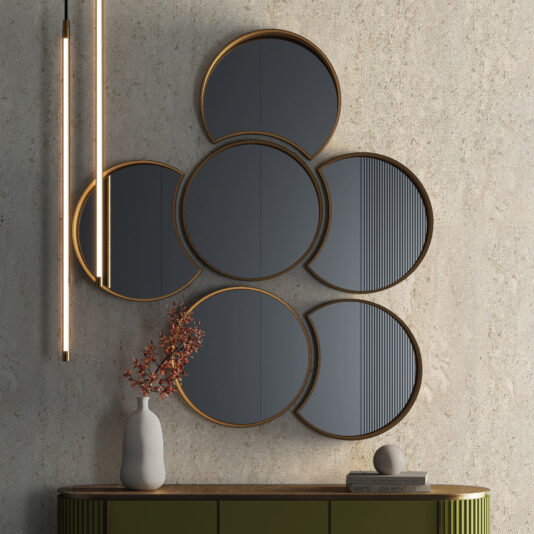 A wall displays the Modern Floating Wall Mirror Cluster—six round gold-framed mirrors grouped together. Nearby, a sleek light fixture hangs. Below, a green console table holds a white vase with orange branches and a gray sphere.