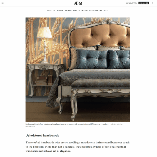 A luxurious bedroom features a bed with a tufted upholstered headboard and an ornate, Marie Antoinette-inspired carved frame, accompanied by an elegant bedside table. Decorative cushions and soft bedlinen enhance the opulent atmosphere.