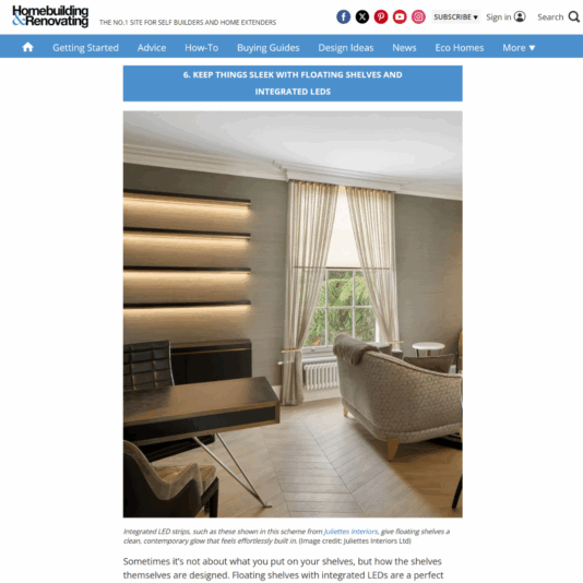 A modern living room with beige armchairs, a large window with tall cream curtains, and sleek floating shelves on the wall illuminated by integrated LED strips.