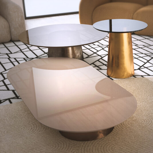 Two Contemporary Glossy Lacquered Coffee Tables with metallic bases rest on a geometric rug, perfectly complementing the beige upholstered furniture in this bright, modern lounge.