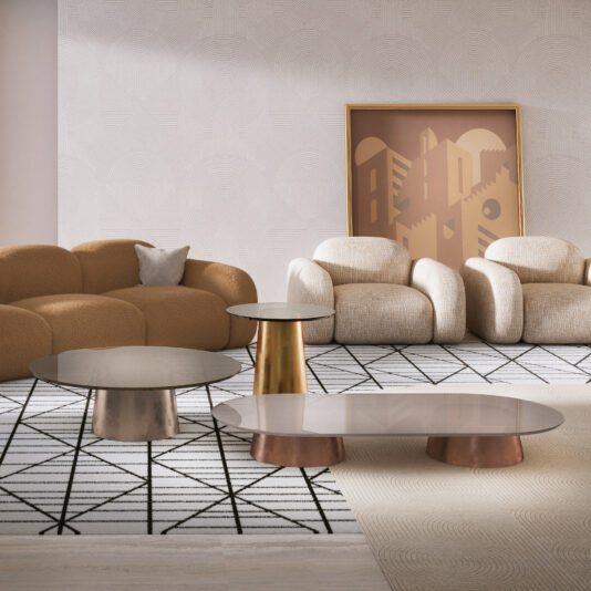 A modern living room features two textured beige armchairs, a brown curved sofa, a set of Contemporary Glossy Lacquered Coffee Tables, a framed abstract art piece on a light patterned wall, and a geometric rug.