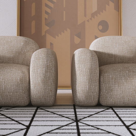 Contemporary Italian Armchair Two Contemporary Italian Armchairs with a modern, textured beige finish and rounded shapes sit side by side on a geometric black-and-white rug, backed by a large, abstract brown-toned artwork.