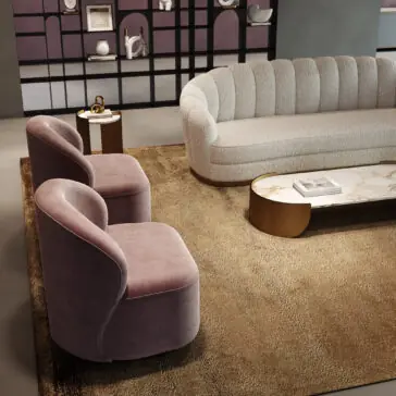 A modern living room with a curved white sofa, two mauve Modern Velvet Occasional Chairs, a beige rug, marble coffee table with books, a small side table, and a decorative shelf with ornaments in the background.