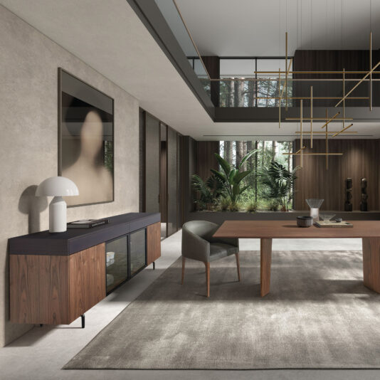 A modern dining room features a wooden table, grey chair, Modern 4 Door Walnut Veneer Sideboard, white lamp, abstract art, large windows, indoor plants, and a geometric gold chandelier—all in a neutral palette.