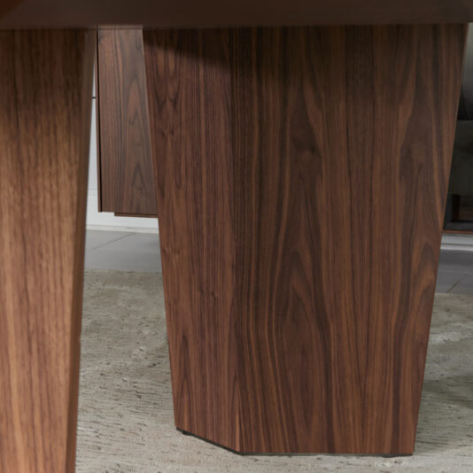 Modern Rectangular Veneer Dining Table Close-up of the Modern Rectangular Veneer Dining Table’s wooden legs on a textured beige rug, showcasing the natural brown wood grain and geometric leg design.