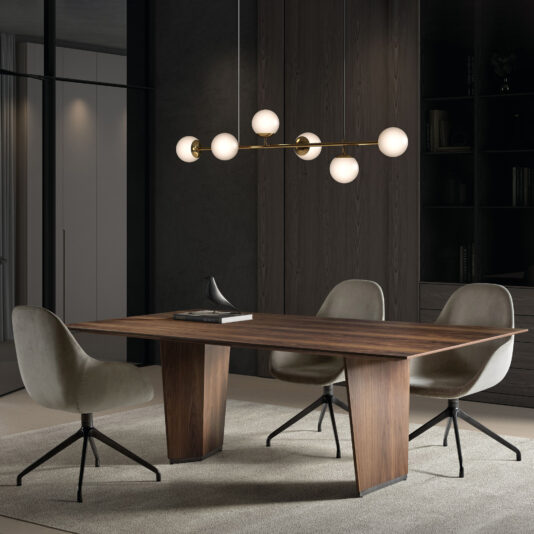Modern Rectangular Veneer Dining Table A modern dining room with a Modern Rectangular Veneer Dining Table, four grey swivel chairs, sculptural decor, and a brass globe chandelier, all set against dark wood-panelled walls and shelves.