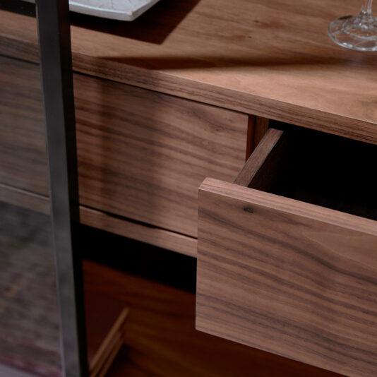 A close-up of the Modern Walnut Veneer Display Cabinet with an open drawer reveals the wood grain, whilst a glass and plate rest partially visible on its surface.