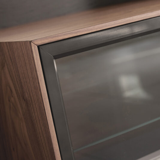 Modern Walnut Veneer TV Cabinet Close-up of a glass display case corner with a wooden frame and black metal trim, showcasing smooth surfaces and modern design inspired by the Modern Walnut Veneer TV Cabinet.