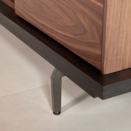 Modern Walnut Veneer TV Cabinet A close-up of the Modern Walnut Veneer TV Cabinet with metal legs on a light tiled floor, showing its dark base and elegant wood grain pattern on the side.