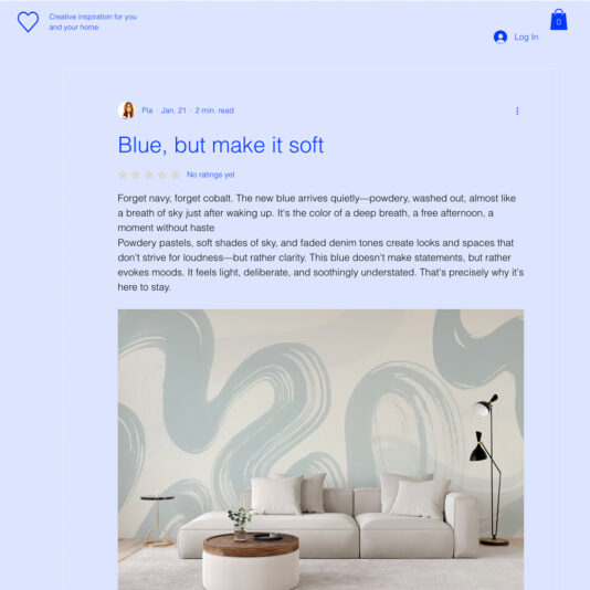 A modern living room features a curved beige sofa, a round wooden coffee table, and a black floor lamp. The wall behind them is decorated with large, soft blue abstract shapes for a calming effect.