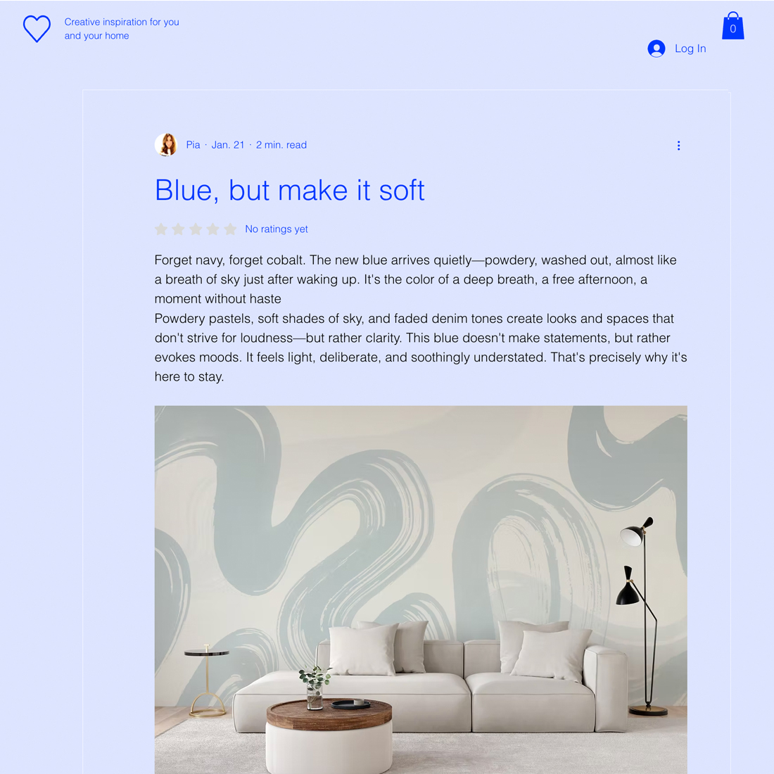 A modern living room features a curved beige sofa, a round wooden coffee table, and a black floor lamp. The wall behind them is decorated with large, soft blue abstract shapes for a calming effect.