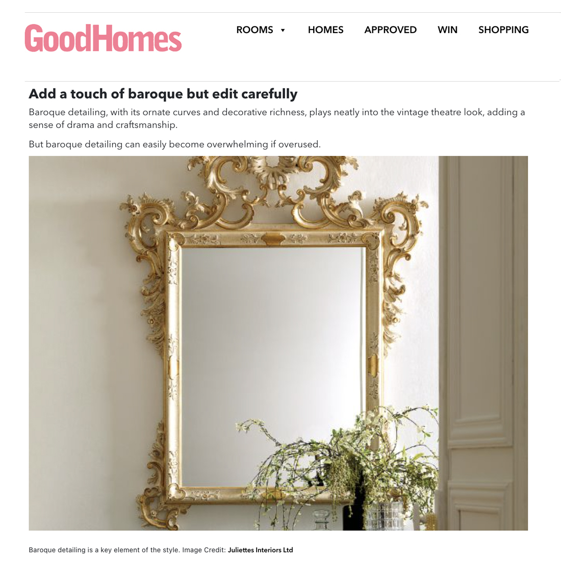 Ornate baroque-style mirror with gold detailing hangs on a white wall above a white mantelpiece, alongside a vase filled with greenery and white flowers.