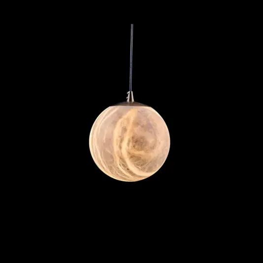 A spherical pendant light with a marbled, cloudy texture glows warmly against a solid black background, suspended by a thin flex from the top.