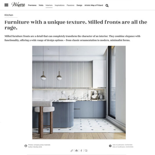 A modern kitchen features light grey milled cupboard fronts, a white marble splashback, minimalist decor, and a small round dining table with two chairs on a patterned floor.