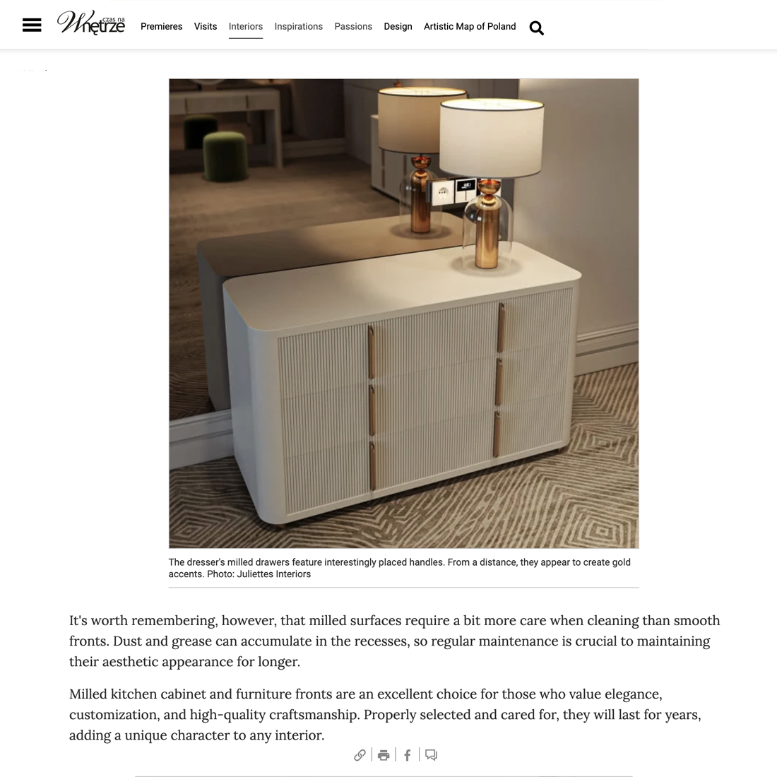A modern cream-coloured chest of drawers with grooved cupboard doors and gold-accented handles stands against a wall, topped with two table lamps and a small decorative item.