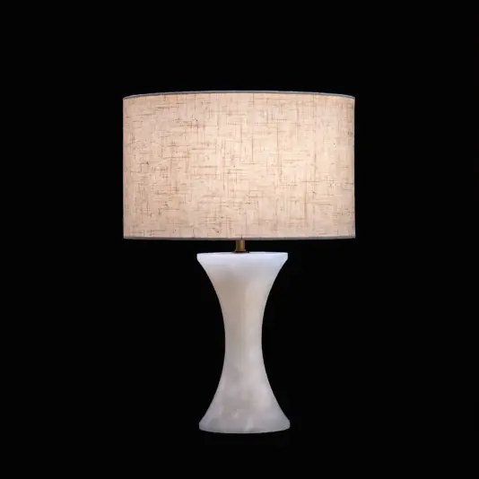 Luxury Concave Table Lamp A modern table lamp with a textured beige lampshade and a smooth, curved white base, illuminated against a black background.