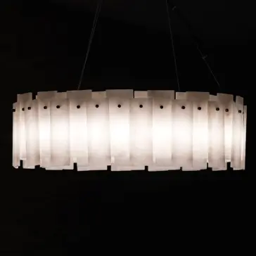 The Elegant Circular Stone Pendant is a modern, oval-shaped light featuring frosted rectangular panels evenly spaced around its perimeter, casting a warm glow against a dark background.