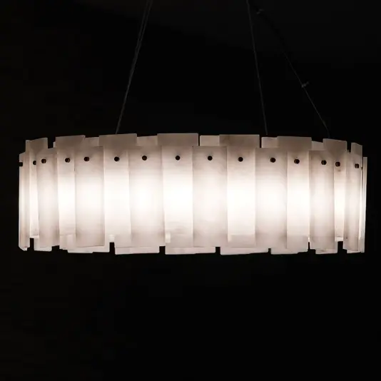 Elegant Circular Stone Pendant Light The Elegant Circular Stone Pendant is a modern, oval-shaped light featuring frosted rectangular panels evenly spaced around its perimeter, casting a warm glow against a dark background.