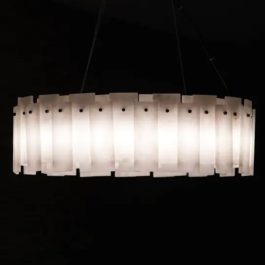 The Elegant Circular Stone Pendant is a modern, oval-shaped light featuring frosted rectangular panels evenly spaced around its perimeter, casting a warm glow against a dark background.