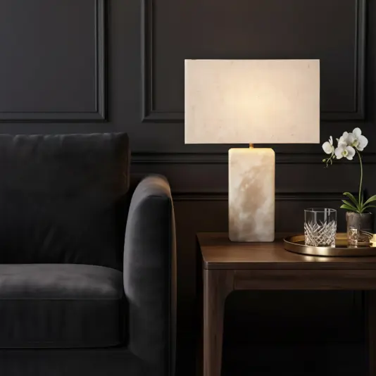 A modern living room with a dark grey sofa, wooden side table holding a Frosted Rectangle Table Lamp, white-shaded, plus a tray with two glasses and a small potted white orchid.