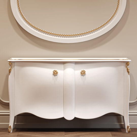 A Classic Style Lacquered Bedside Cabinet (Copy), featuring curved legs, gold accents, and ornate gold handles on two doors, stands against a beige wall beneath a round mirror with a gold-beaded frame.
