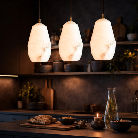 Three Contemporary Alabaster Pendant Lights with frosted geometric shades illuminate a cosy kitchen counter adorned with bread, nuts, a lit candle, and a carafe. The space features plants and wooden accents for a warm atmosphere.