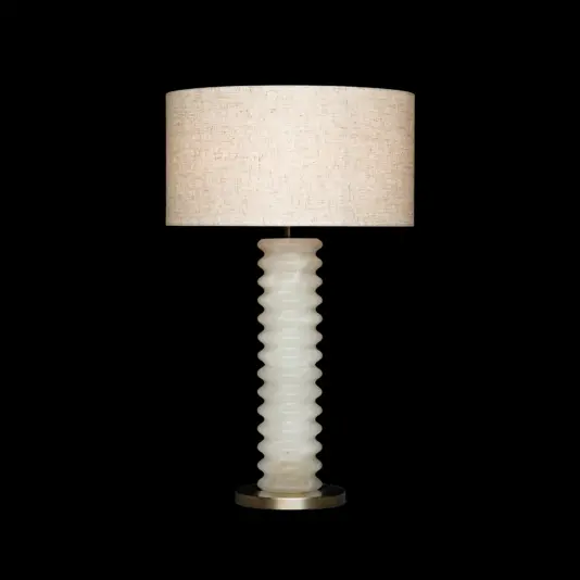 A table lamp with a textured, wavy white base and a large, cylindrical beige fabric lampshade, set against a plain black background.