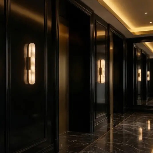 Modern lozenge shape Wall Light A modern corridor with dark panelled walls, illuminated by sleek vertical wall lights, and a glossy black marble floor reflecting warm ceiling lights.