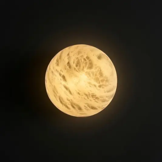 Luxury Round Wall Light A round, yellowish-white light fitting glows against a dark background, resembling a glowing full moon with marbled patterns on its surface.