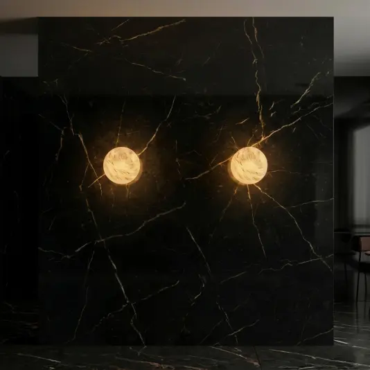Luxury Round Wall Light A dark marble wall with gold veining features two round, glowing wall lamps emitting warm light, creating a dramatic and elegant atmosphere in a modern interior space.