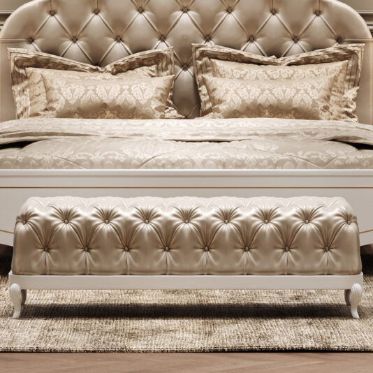 Elegant Button Upholstered Bench The Elegant Button Upholstered Bench rests at the foot of a tufted cream bed with ornate pillows and bedding, all atop a textured rug, creating a luxurious and sophisticated bedroom atmosphere.