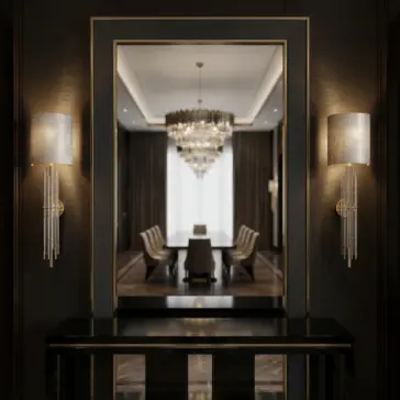A modern, elegant dining room is reflected in a large wall mirror, framed by two sleek wall sconces with silver shades. A crystal chandelier hangs above a long dining table with upholstered chairs.