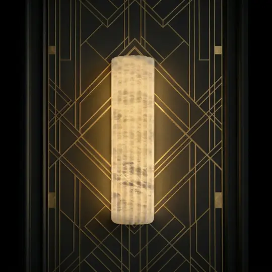 The Luxury Fluted Wall Light features a glowing, textured design and is mounted on a black wall with gold geometric Art Deco patterns.