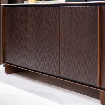 A close-up of the Contemporary Hammered Oak Veneer Sideboard featuring textured, wavy front panels, placed on a light-coloured floor.