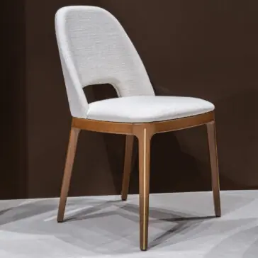 Mid Century Inspired Dining Chair The Mid-Century Inspired Dining Chair features a white upholstered seat and backrest with a wooden frame and four angled legs, set against a dark brown background on a light-coloured floor.