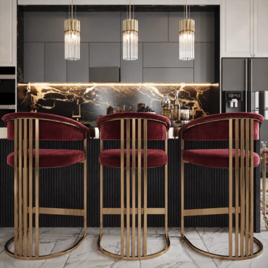 Art Deco Inspired Curved Burgundy Velvet Bar Stool Three Art Deco burgundy velvet bar stools with oxidised metal frames and curved backs at a marble kitchen island.