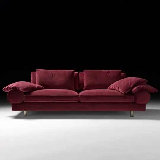 Burgundy sofa with retro bolster arms, piped cushions and dark bronze legs, viewed from the front.