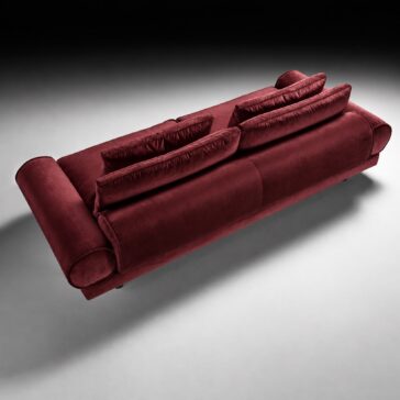 Burgundy Sofa with Retro Inspired Design Burgundy retro sofa viewed from above and behind, showing the upholstered back and layered cushions.