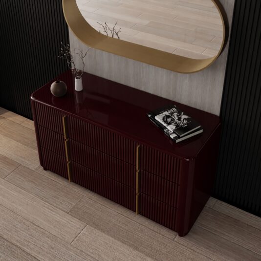 Burgundy Gloss Ribbed Chest of Drawers Raised oblique view of the burgundy gloss chest beside an oval gold-framed mirror