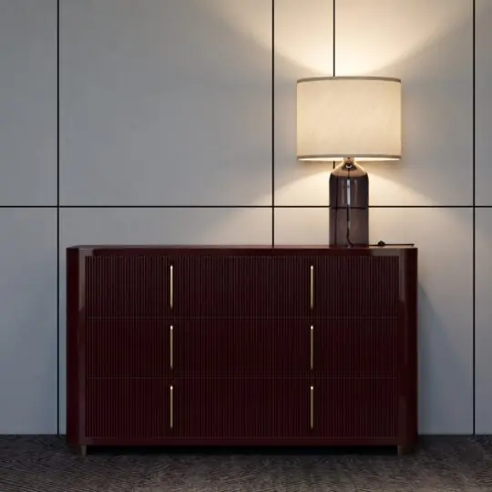 Burgundy ribbed chest of drawers with a gloss finish beneath a table lamp