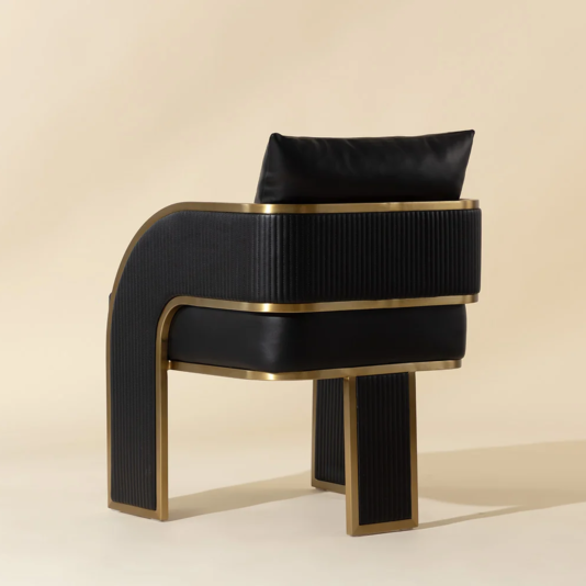 Rear view of the black faux leather dining chair with channel-stitched upholstery and gold frame