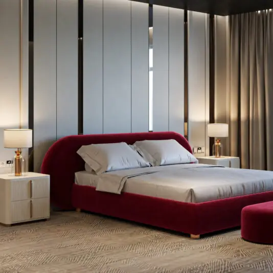 Curved Contemporary Burgundy Velvet Bed Angled view of a burgundy velvet bed with a wide curved headboard, pale bedding and matching bench.